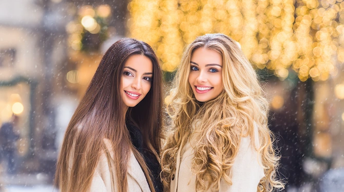 Lunghi capelli lisci castani e ricci biondi in un’atmosfera natalizia.